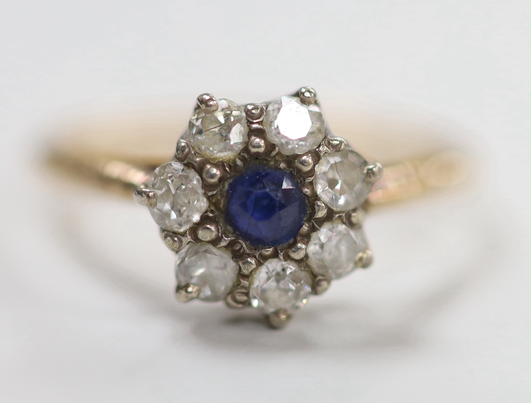 A yellow metal, sapphire and diamond set cluster ring, size N, gross weight 2.2 grams.